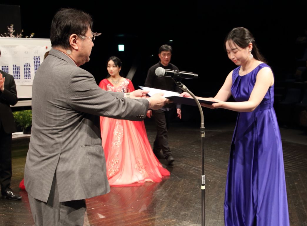 実行副委員長田中英成氏より奨励賞を授与される花井美奈穂さん